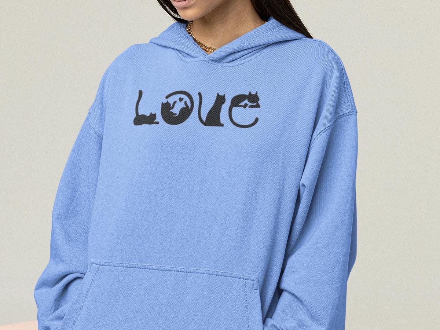 a woman wearing a blue hoodie with the word love printed on it